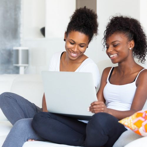 African American student girls using a laptop computer - black people